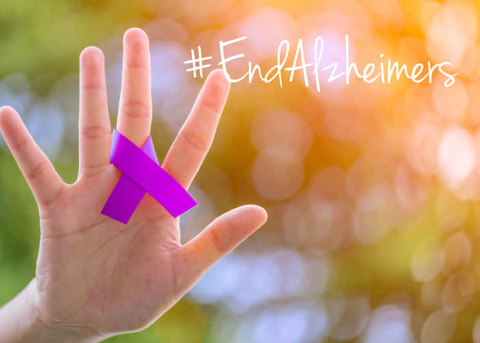 end alzheimers. Hand with purple ribbon wrapped around finger